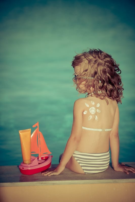 little girl with a sun drawn on her back in sunscreen - find the best sunscreen for kids with these tips