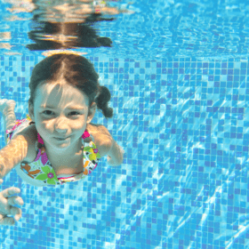 girl swimming underwater in pool