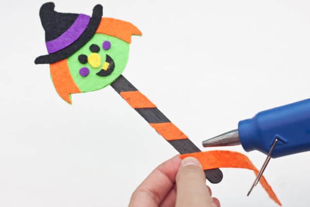 Witch Halloween bookmarks craft for kids tutorial, adding orange diagonal strip to popsicle stick