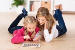 mom and daughter on the floor with a tablet exploring fun activities to do at home with kids