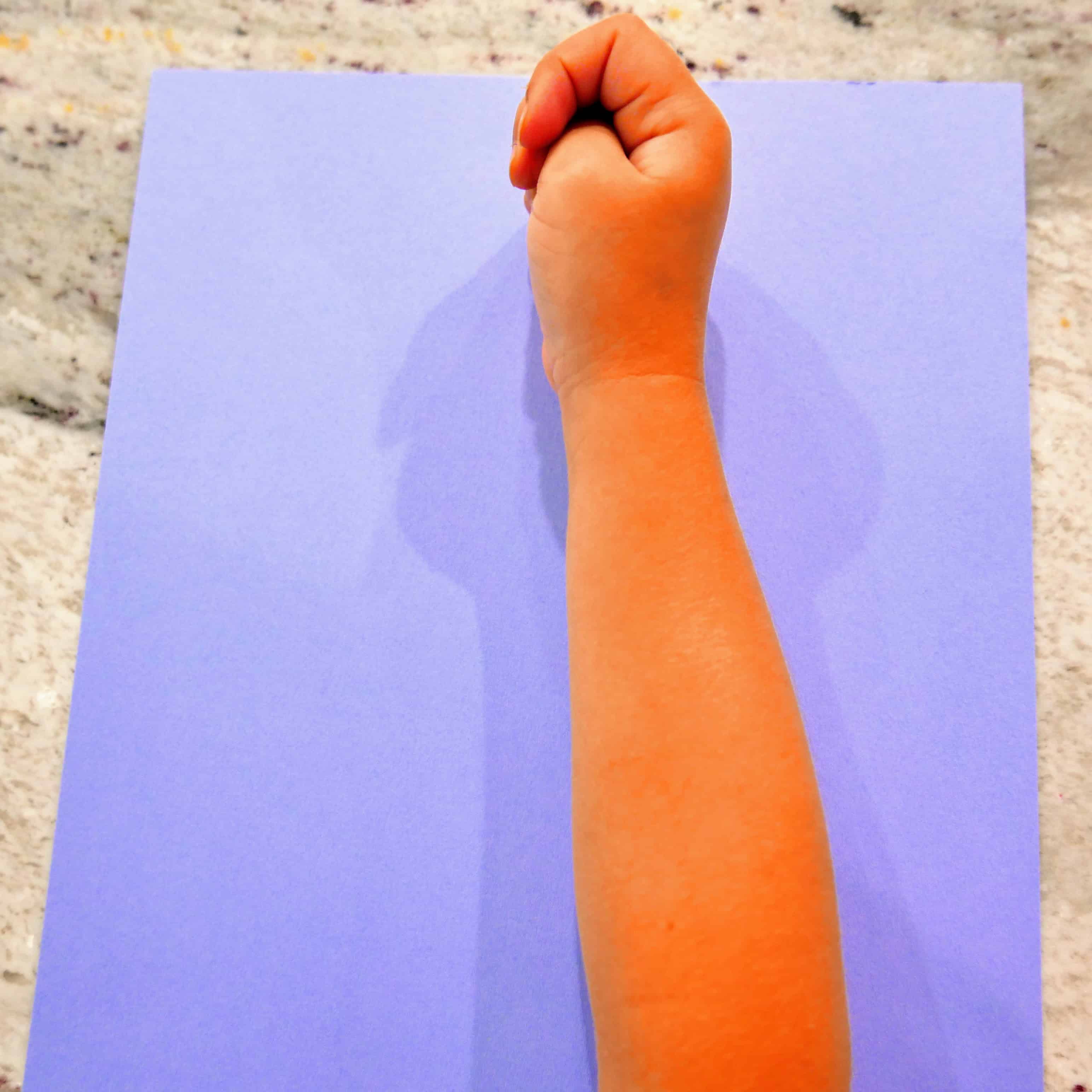 child's arm on top of cardstock paper