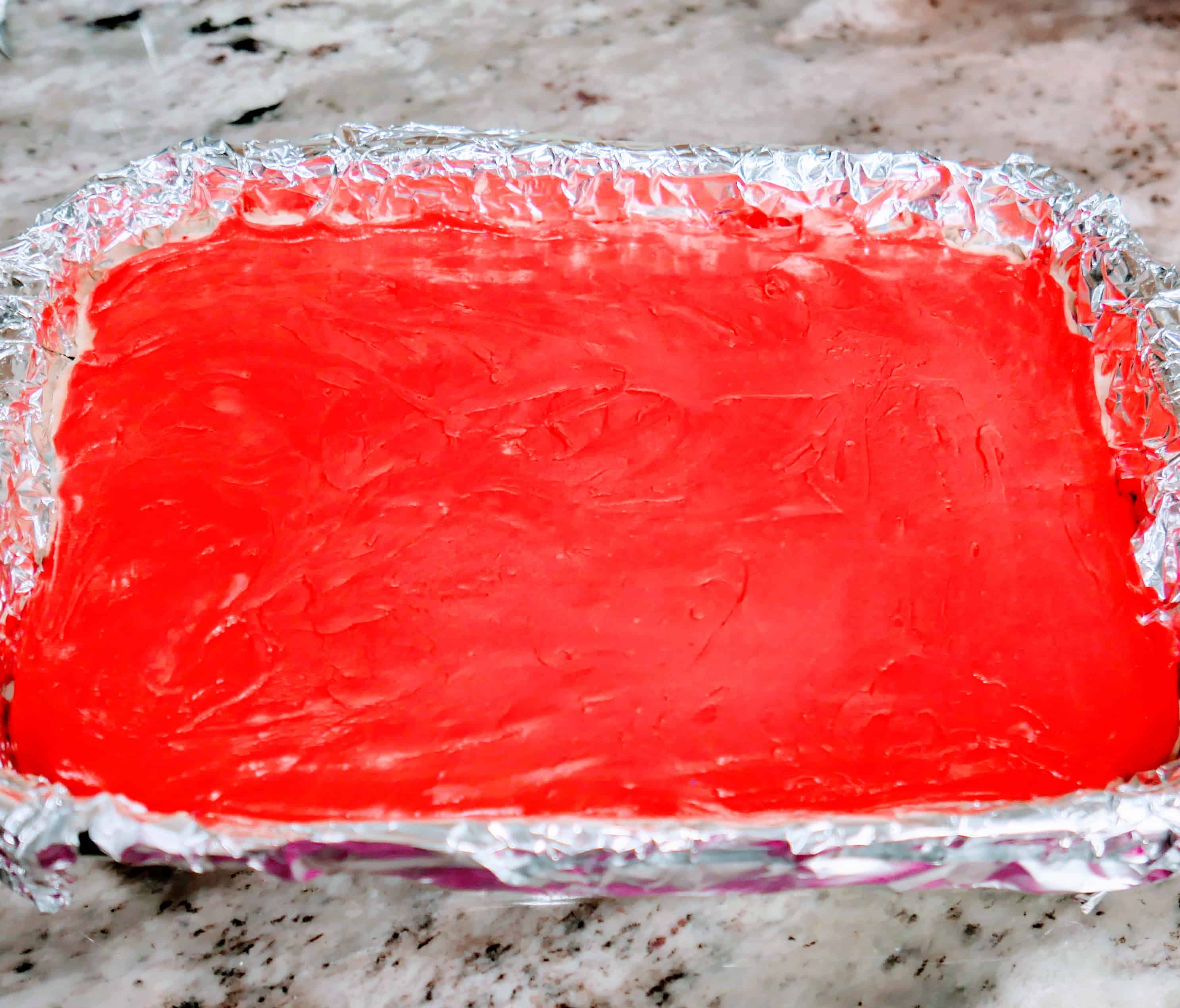 red vanilla fudge mixture on top of the other layers