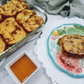 pumpkin french toast on a plate with a pan holding more next to it