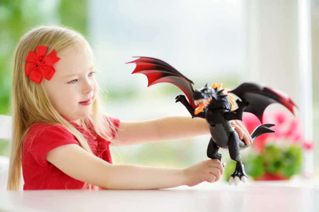 girl playing with dragon toys