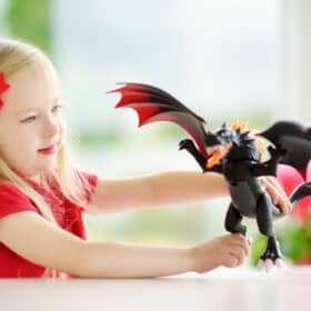 girl playing with a toy dragon