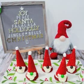 Santa gnome cookies on a tray in front of a Santa gnome and letter board