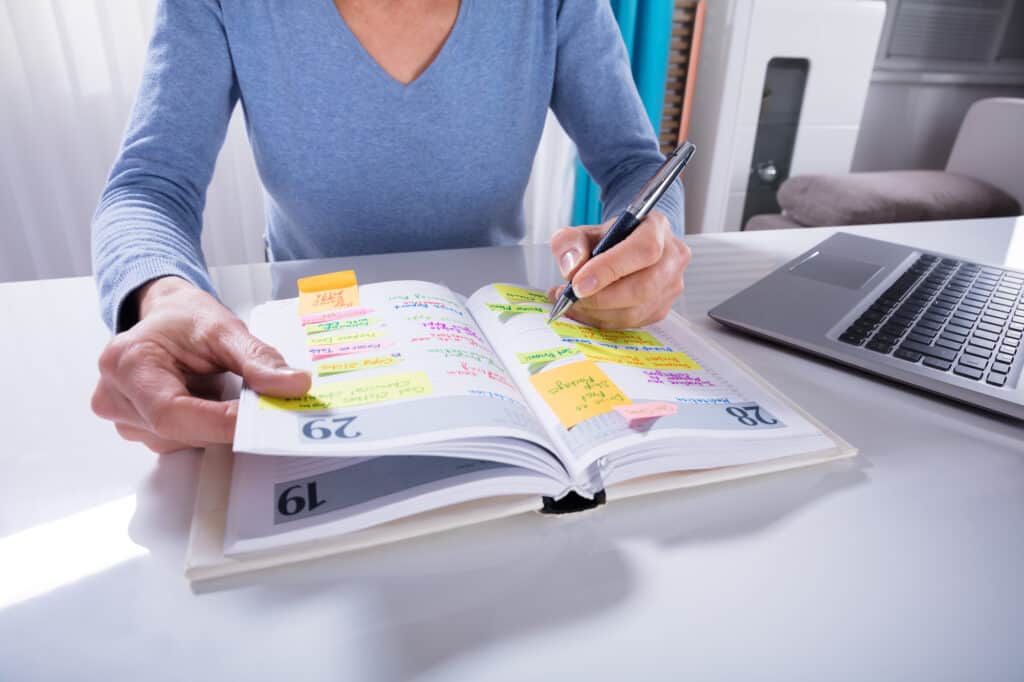 woman writing in one of the best planners for moms