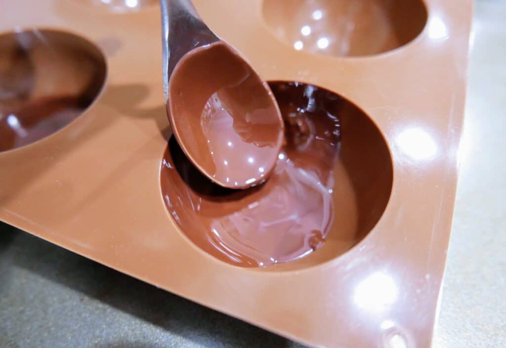 painting the silicone mold with melted chocolate