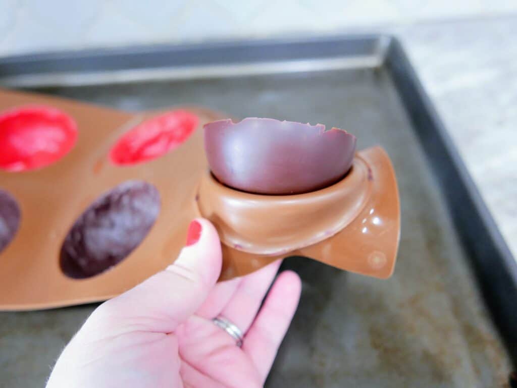 peeling the silicone mold away from chocolate cups