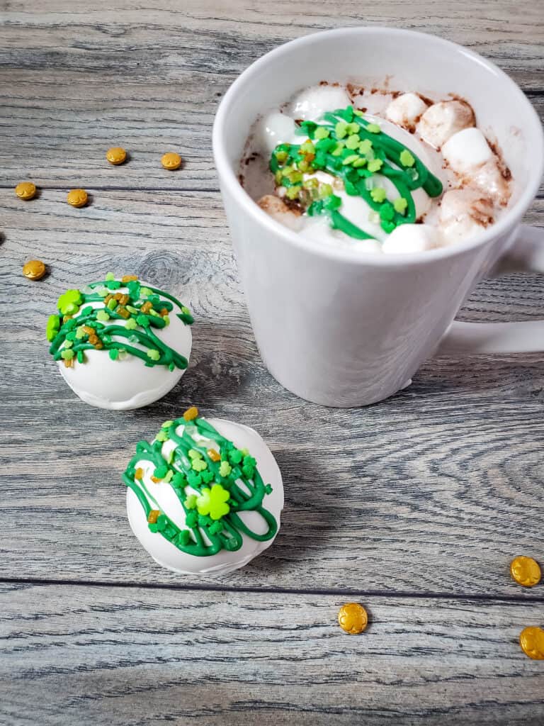 St. Patrick's Day hot cocoa bombs and mug of hot chocolate