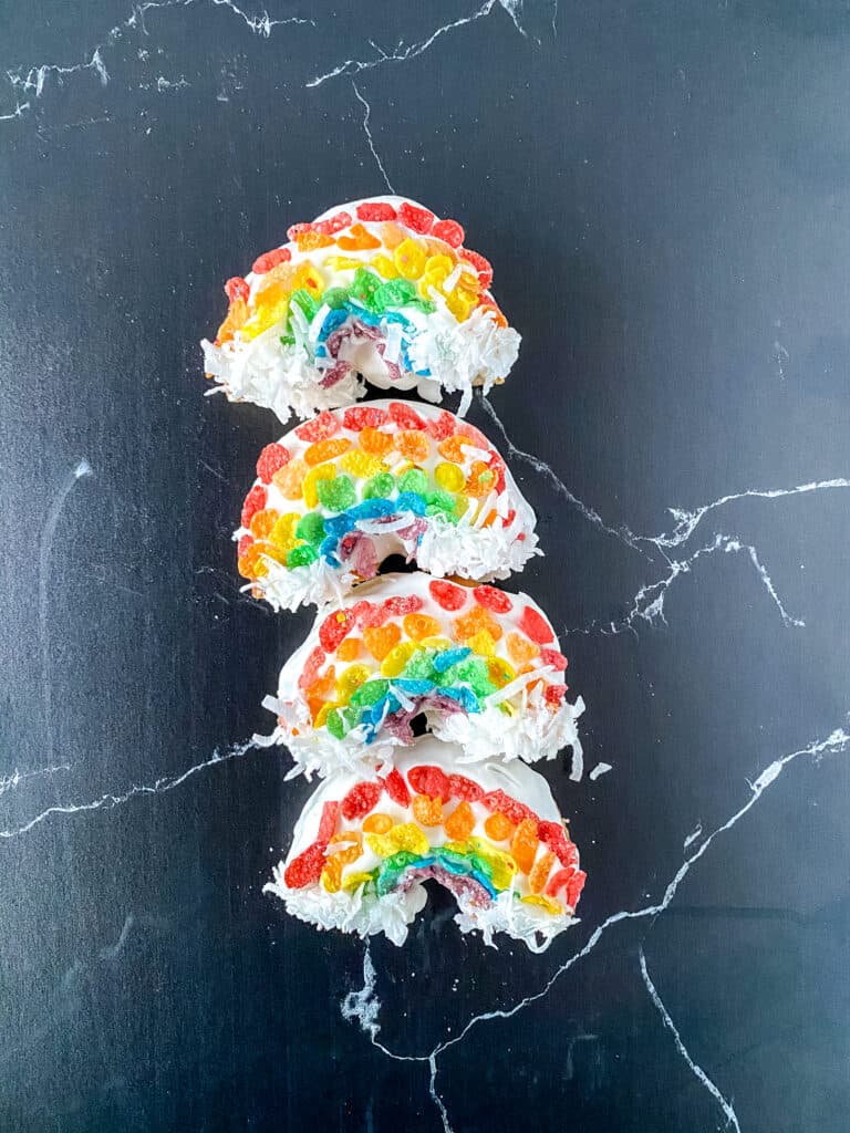 Rainbow Donuts! Make these fun donuts with fruity pebbles, white frosting, and coconut! They are SO easy to make that you'll do it again and again to your kids' delight!