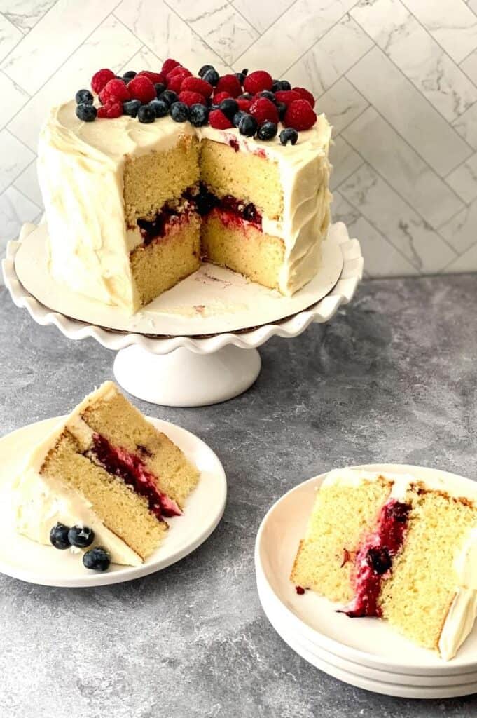 berry Chantilly cake on platter with slices on plates