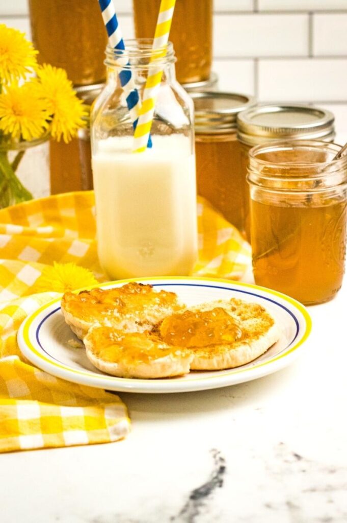 jars of homemade fruit spread and an English muffin on a plate