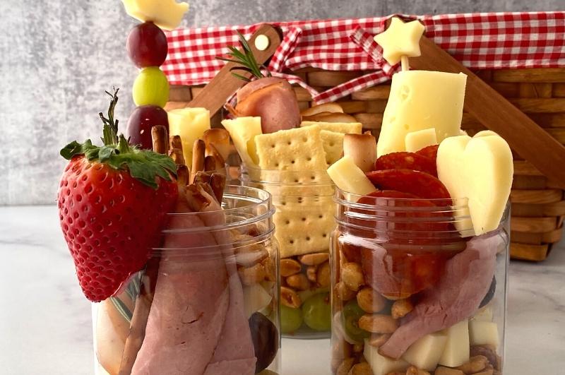savory jarcuterie jars with a picnic basket in the background