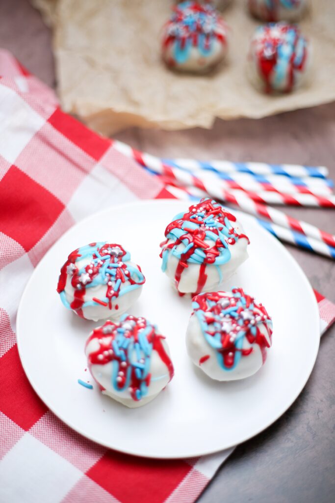 red, white, and blue cake balls on a plate