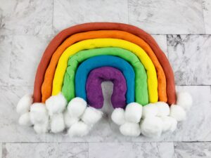 rainbow made out of colored homemade playdough with cotton balls for clouds