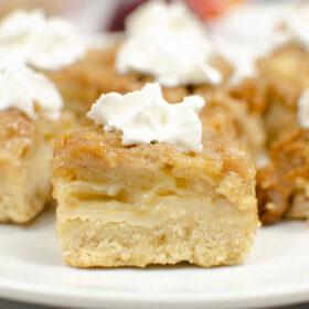 close up of apple crisp bars with whipped cream