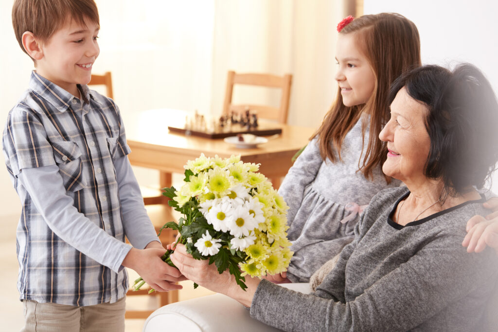 child giving flowers to his grandma as acts of kindness for kids