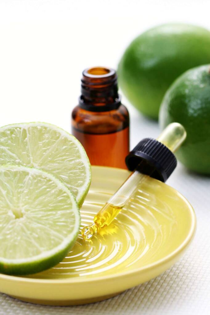 cup open lime with bottle of essential oil