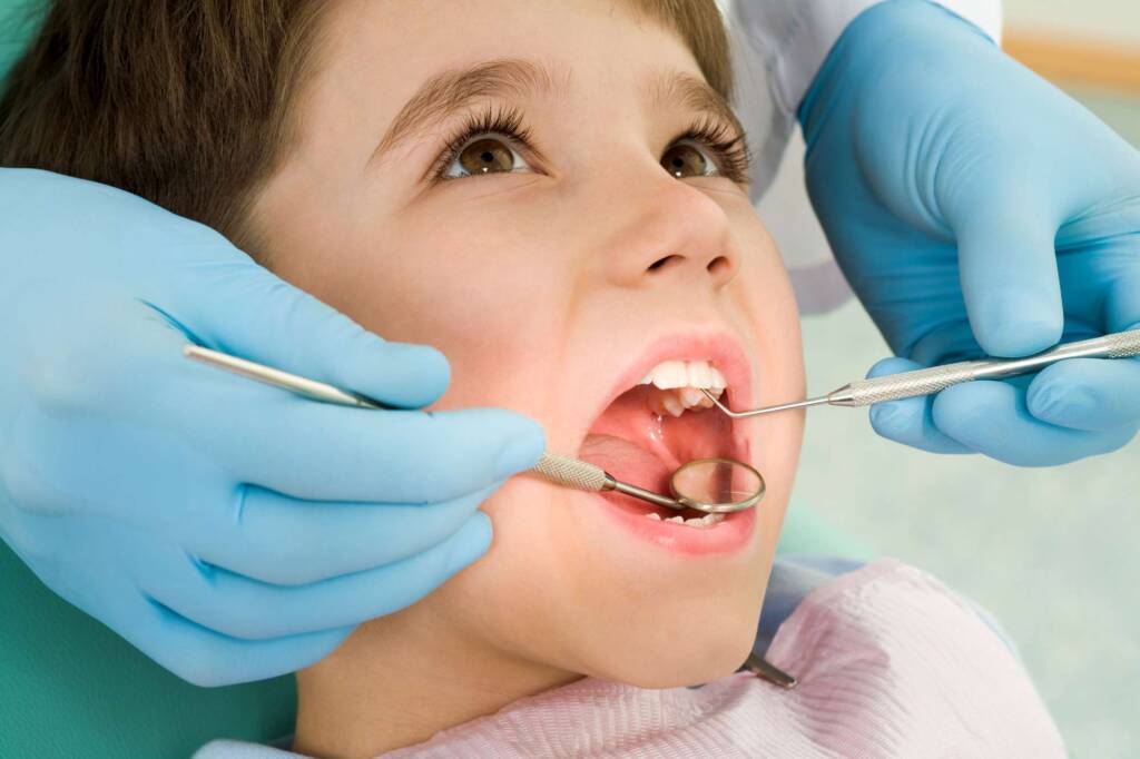 dentist checking boy's teeth
