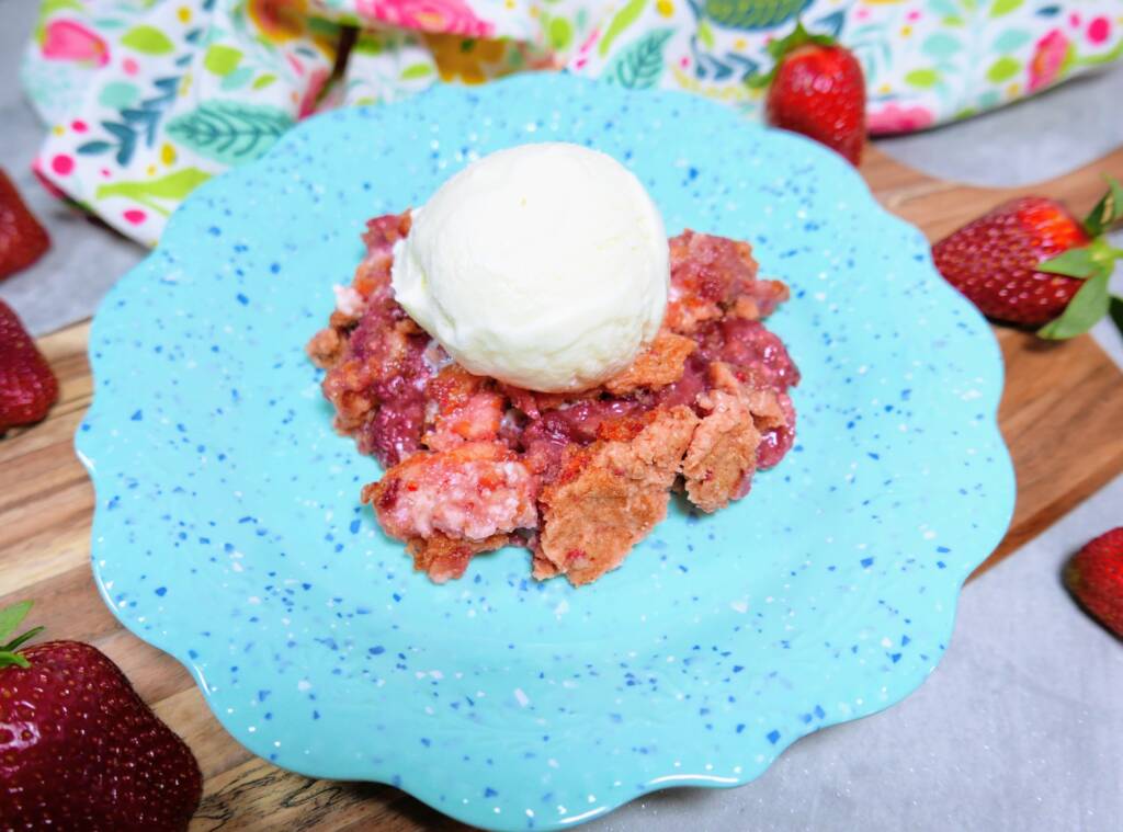 strawberry crumble with a scoop of ice cream on a blue plate