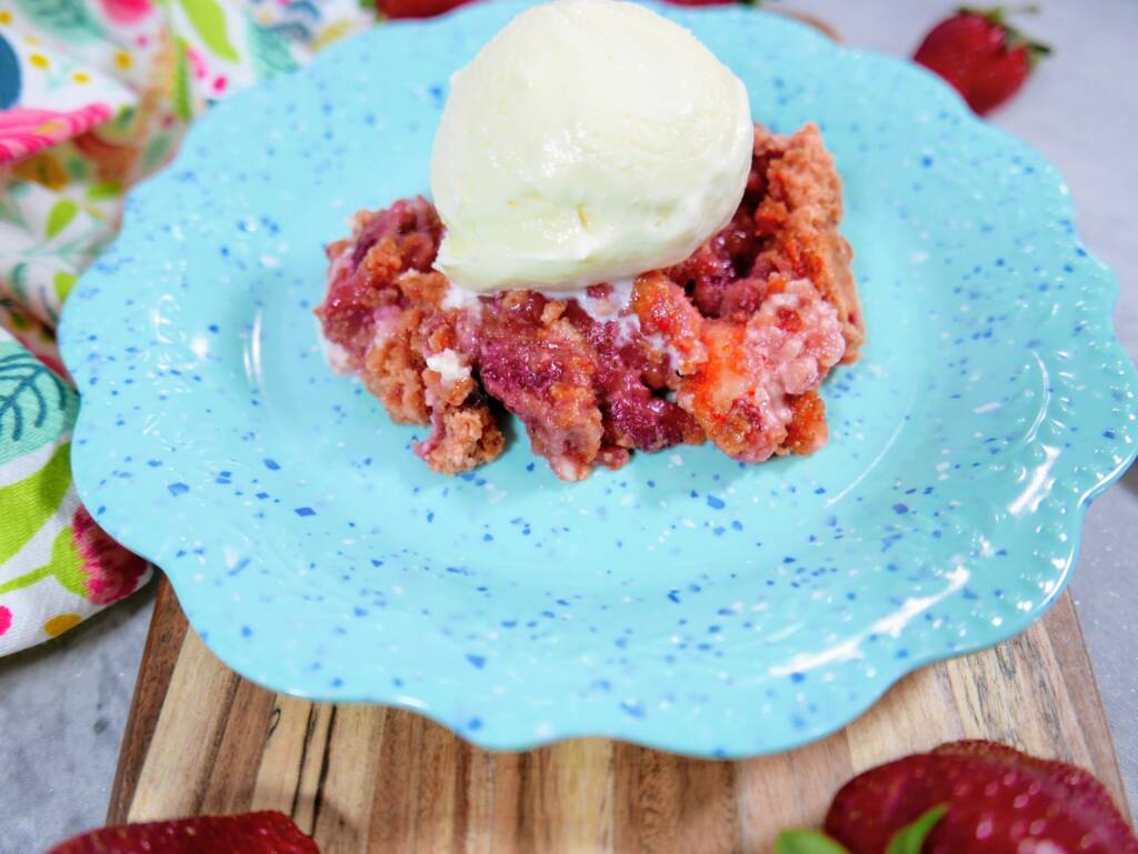 strawberry crumble with a scoop of ice cream on a blue plate