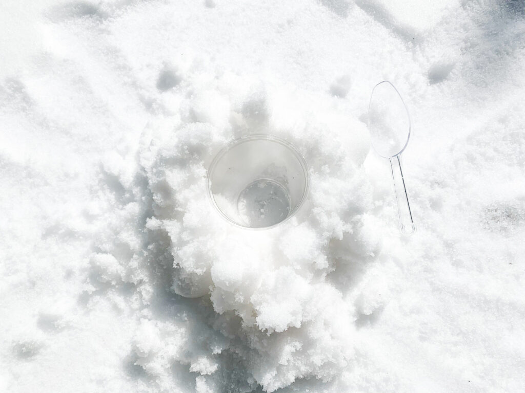 inserting plastic cup into the snow