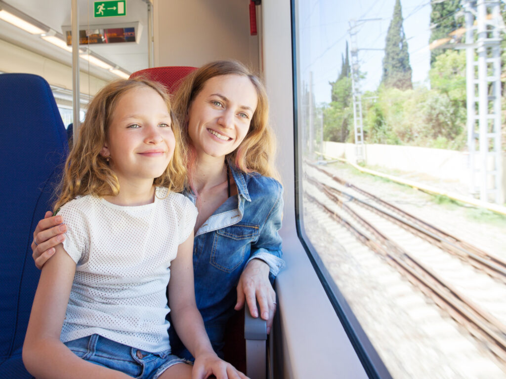 mom and daughter sitting on train