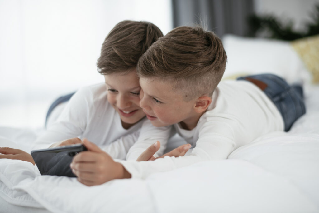 two boys playing on a phone