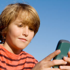 boy sitting outside on cell phone