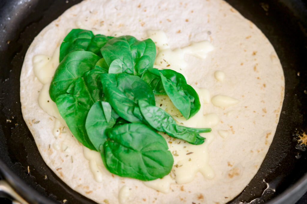 adding spinach on top of cheese