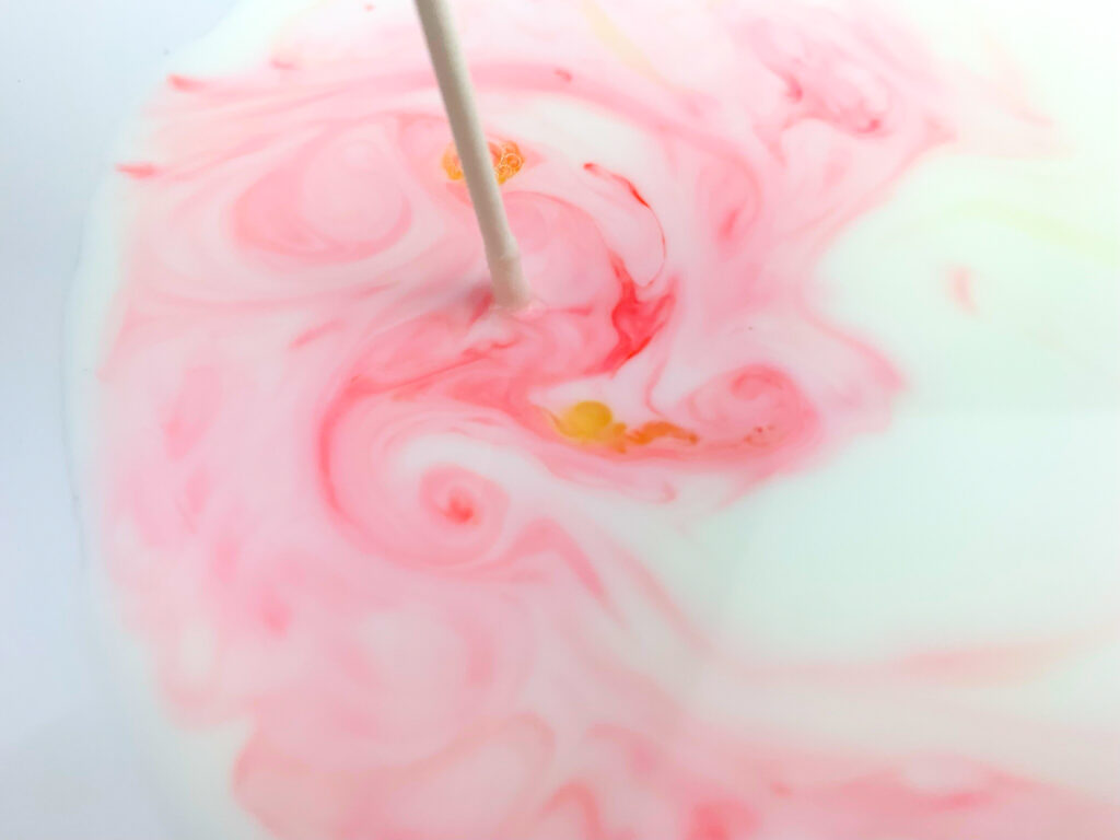 swirling food coloring around milk