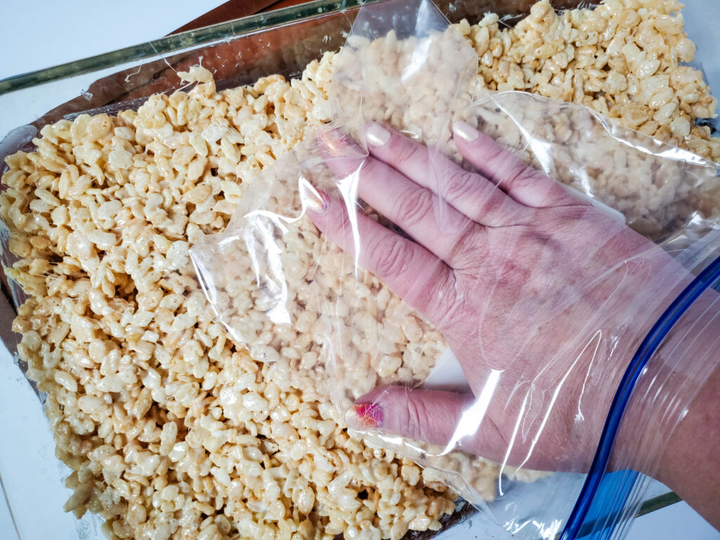 pressing rice krispies into a pan