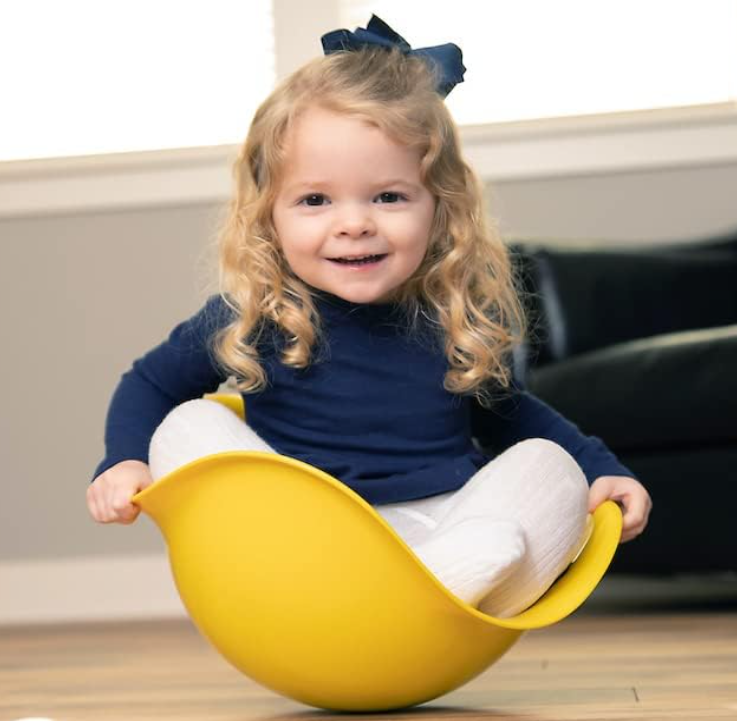 toddler girl sitting in a yellow Bilibo toy